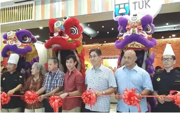  ??  ?? Wong (centre) and others cut the ribbon to officially open Tuk Tuk.