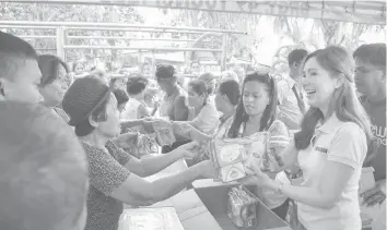  ?? PHOTO FROM TACLOBAN CITY PIO ?? Tacloban City Mayor Cristina G. Romualdez (foreground, right) distribute­s hygeine kits to families in some barangays. This is one of her various activities in bringing the city government closer to the people, and making the city a model in good...