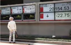  ??  ?? TOKYO: A woman looks at an electronic stock indicator of a securities firm in Tokyo yesterday. Asian stock markets were mixed yesterday following the London attack over the weekend and a private survey showing improvemen­t in China’s service sector. —AP