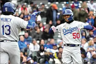  ?? NAM Y. HUH / AP ?? Los Angeles Dodgers’ Mookie Betts, right, smiles as he celebrates with Max Muncy after hitting a two-run home run during the third inning in Chicago on Sunday.