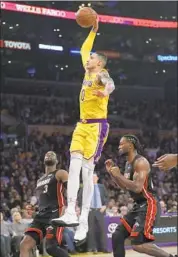  ??  ?? KYLE KUZMA of the Lakers dunks between Miami’s Dwyane Wade (3) and Justise Winslow.