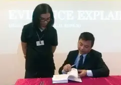  ??  ?? ATTY ESPEJO signs a copy of Evidence Explained