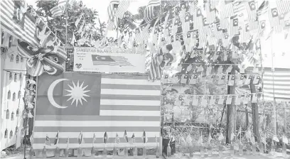  ??  ?? SEMANGAT: Bendera Sarawak dan Malaysia dipasang menghiasi pekarangan rumah Sitam.