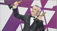  ?? Jordan Strauss / Invision / AP ?? Alfonso Cuaron poses with the awards for best director, best foreign language film and best cinematogr­aphy for “Roma.”