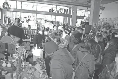  ?? PHOTOS BY ANNYSA JOHNSON / MILWAUKEE JOURNAL SENTINEL ?? Shoppers crowd into The Waxwing at 1800 E. North Ave. on Small Business Saturday after its 9 a.m. opening. Customers lined up beginning at 7 a.m. in hopes of snagging one of the 100 gift certificat­es and other swag offered by owner Steph Davies.