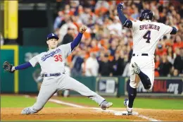  ?? Associated Press photo ?? Houston Astros’ George Springer beats Los Angeles Dodgers’ Cody Bellinger to first base during the sixth inning of Game 3 of baseball’s World Series, Friday, in Houston.