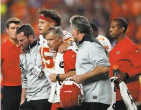  ?? Matthew Stockman / Getty Images / TNS ?? Chiefs quarterbac­k Patrick Mahomes, the reigning NFL MVP, is helped off the field after suffering a knee injury in the first half against the Broncos.