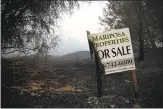  ?? JUSTIN SULLIVAN — GETTY IMAGES ?? A half-burned real estate sign stands on the side of the road during the Detwiler fire in Mariposa on Wednesday.