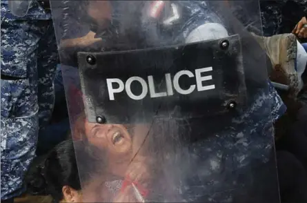  ?? HUSSEIN MALLA — THE ASSOCIATED PRESS ?? A riot policeman removes an anti-government protester Saturday who is blocking a main highway in Beirut, Lebanon. Lebanese security forces pushed and dragged away protesters who refused to move from roadblocks to reopen roads closed during a campaign of civil disobedien­ce.