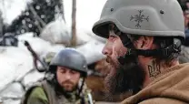  ?? Anatolii Stepanov / AFP via Getty Images ?? A Ukrainian serviceman with a tattoo of Ukraine’s coat of arms stands at his position on the front line Thursday.