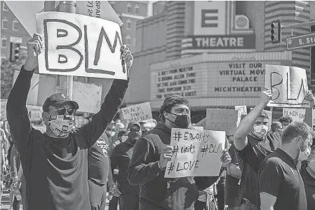  ??  ?? At a protest in Ann Arbor, Grant Perry ( left), Mike McCray, Grant Newsome and Jay Harbaugh ( far right) were among former and current players and coaches from the Michigan Wolverines football program who participat­ed.