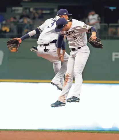  ??  ?? Orlando Arcia and Ryan Braun celebrate the Brewers’ victory.