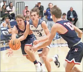  ?? Scott Herpst ?? Gordon Lee’s Cayden Powell brings the ball up the floor, guarded by Heritage’s Caden Snyder (left) and Cade Kiniry (right).