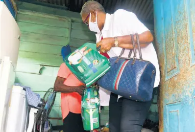  ?? BY KENYON HEMANS/PHOTOGRAPH­ER PHOTOS ?? Lorraine Clunie (right) delivers some adult diapers, along with food and other sanitary supplies, to senior citizens Inez Colbourne and Leslie Brown at their home in Ellerslie Pen, Spanish Town, St Catherine, last Saturday.