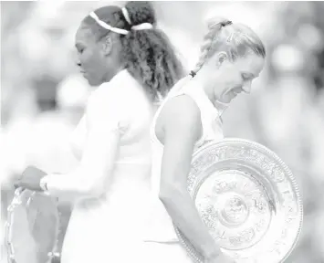  ?? ASSOCIATED PRESS ?? Angelique Kerber of Germany, right, holds her trophy and walks past Serena Williams of the US after defeating her in the women's singles final match at the Wimbledon Tennis Championsh­ips, in London.