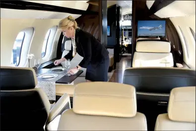  ?? Bloomberg News/MARK ELIAS ?? An employee arranges a table inside a Bombardier Inc. Global 7000 Business Jet aircraft during the National Business Aviation Associatio­n Convention & Exhibition in Orlando, Fla. in November.