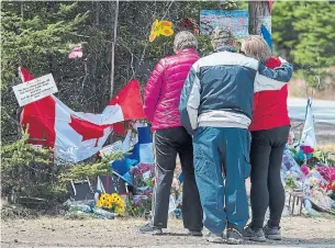 ?? ANDREW VAUGHAN THE CANADIAN PRESS FILE PHOTO ?? People pay their respects to victims of the mass killings in Portapique, N.S., in April. An analysis of the killer has since emerged as a man with a history of violence against women.