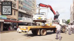  ?? - Picture: Joseph Manditswar­a ?? Municipal police tow away a vehicle from George Silundika Avenue as “Operation Chenesa Harare,” intensifie­d yesterday.