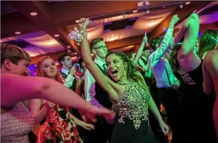  ?? Michael M. Santiago/Post-Gazette ?? Jenna Joseph, of Swissvale, center, dances with friends during the Woodland Hills Junior/Senior Prom on May 17 at Stratigos Banquet Center in North Huntingdon.