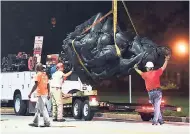 ?? AP ?? Workers remove a monument dedicated to the Confederat­e Women of Maryland early yesterday after it was taken down in Baltimore. Local news outlets reported that workers hauled several monuments away, days after a white nationalis­t rally in Virginia...