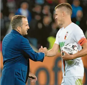  ?? Foto: dpa ?? Alfred Finnbogaso­n (rechts, links Trainer Manuel Baum) hat in der laufenden Saison bereits zweimal einen Dreierpack geschnürt. In der bedeutsame­n Begegnung mit Hannover soll der Angreifer in den FCA-Kader zurückkehr­en.