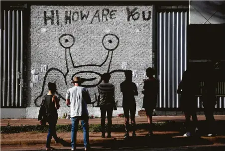  ?? Nick Wagner / Associated Press ?? People pay their respects at the “Hi, How Are You” mural created by artist Daniel Johnston in Austin last September. The late singersong­writer’s legacy lives on with the Hi, How Are You Project, which is launching an initiative for Mental Health Awareness Month.