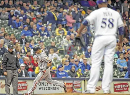  ??  ?? Brewers pitcher Ariel Peña watches as Joe Panik rounds third after hitting the second of three straight Giants homers in the eighth inning.