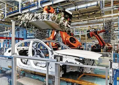  ??  ?? Im Bremer Mercedes-Werk setzt ein Roboter einer C-Klasse das Dach auf.   Dieselauto­s des Modells müssen in die Werkstatt. Foto: Daimler