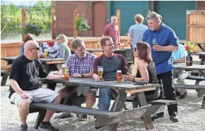  ?? / MILWAUKEE JOURNAL SENTINEL ?? Beer lovers enjoy a pint on the patio at City Lights Brewing. The brewery at 2210 W. Mount Vernon Ave. is planning Firkin Fridays in July.