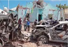  ??  ?? MOGADISHU: People stand next to wreckage of vehicles on the scene of a car bomb attack in Mogadishu in the southern district of Wadajir yesterday. — AFP