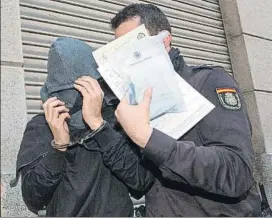  ?? FOTO: EFE ?? Un policía nacional traslada a uno de los detenidos de la supuesta a trama de amalos