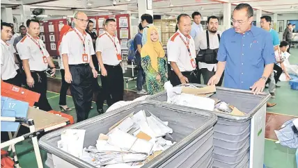  ??  ?? Jailani (right) visits a section at Pos Malaysia Berhad’s mail centre. — Bernama photo