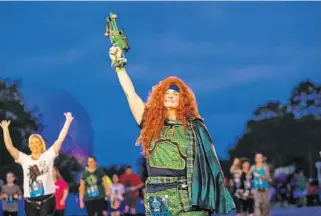  ?? JACOB LANGSTON/STAFF PHOTOGRAPH­ER ?? Carrie Nugent of Winter Park crosses the finish line Friday morning during the Star Wars Dark Side 5K.