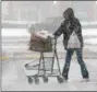  ?? GENE WALSH — DIGITAL FIRST MEDIA ?? A shopper navigates her cart through the snow at the Lower Providence Acme on Friday.