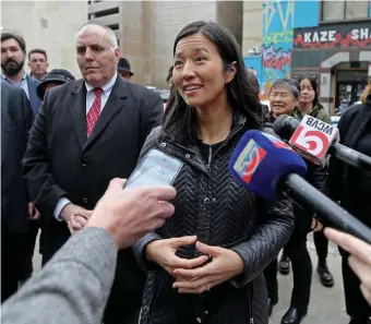  ?? STuART cAHILL / HeRALd STAFF ?? SAY CHEESE: Mayor Michelle Wu speaks to the media during a walking tour Thursday of art in Chinatown. Below, protesters gather outside Wu’s house on Wednesday morning.