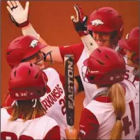  ??  ?? Arkansas players congratula­te Hannah Gammill (left) after her three-run home run in the first inning of Monday’s 8-4 victory over Missouri. The Razorbacks rebounded after dropping the first two games of the series.
(Photo courtesy University of Arkansas Athletics)