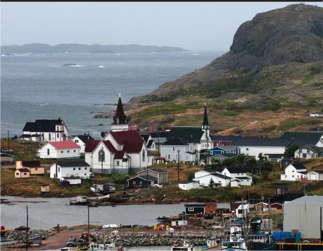  ??  ?? Brimstone Head rises over busy Fogo Harbour on the north shore of Fogo Island.