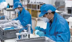  ??  ?? Above: SAIC-GM-Wuling Automobile achieved production capacity of 500,000 masks a day by midFebruar­y, and 15 production lines to manufactur­e 2 million masks a day were in operation by the end of February. — Ti Gong