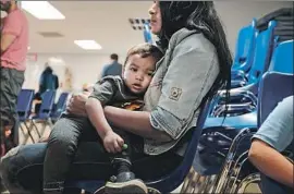  ?? Spencer Platt Getty Images ?? AN IMMIGRANT and her son wait at a Catholic Charities center in McAllen, Texas. The Trump administra­tion’s “zero tolerance” policy remains in effect.