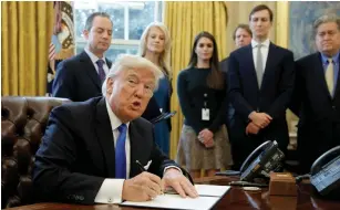  ?? (Kevin Lamarque/Reuters) ?? US PRESIDENT Donald Trump looks up while signing an executive order to advance constructi­on of the Keystone XL pipeline at the White House in Washington on Tuesday.