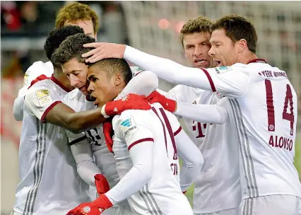  ?? — AP ?? Bayern’s Robert Lewandowsk­i celebrates with teammates after scoring against SC Freiburg in Freiburg on Friday.