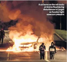  ?? KEVIN SCOTT/PRESSEYE ?? A car burns on the rail tracks at Antrim Road during disturbanc­es in Lurgan
on Sunday night