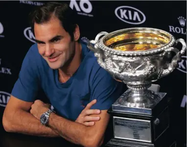  ??  ?? NICE TO HAVE THIS NEXT TO ME AGAIN: Roger Federer talks to the media with the Australian Open trophy beside him after his superb five-set win over Rafa Nadal.