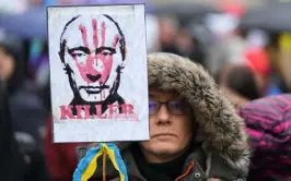  ?? Petr David Josek, The Associated Press ?? A demonstrat­or holds a placard of Russia’s Vladimir Putin on Saturday in Budapest, Hungary.