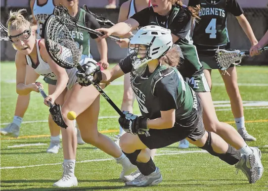  ?? Staff photos by patRICK WhIttEMoRE ?? STICK IT TO ’EM: Molly Rose Kearney, above, slotting a backhand past Manchester Essex goalie Isabella Pomeroy on Thursday, and the rest of the Newburypor­t lacrosse team are trying to right the sour end to last season in the Div. 2 state semifinals.