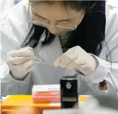  ?? — Reuters ?? Dr Shuhui Sun performs a step of histologic­al staining of mouse liver for pathologic­al analysis in the Aging and Regenerati­on lab in Beijing.