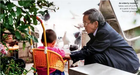  ??  ?? An elderly resident takes care of a child at a park in Qujing, Yunnan province