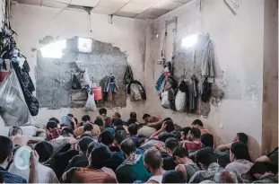  ??  ?? MOSUL: Suspected Islamic State members sit inside a small room in a prison south of Mosul. —AP