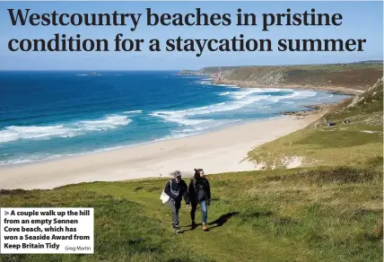  ?? Greg Martin ?? > A couple walk up the hill from an empty Sennen Cove beach, which has won a Seaside Award from Keep Britain Tidy