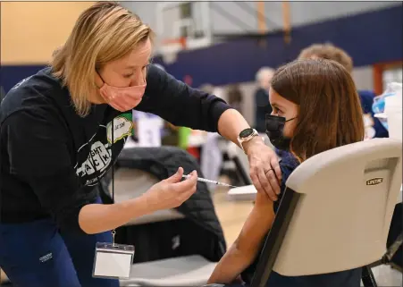  ?? PHOTO COURTESY ALLISON BARTO PHOTOGRAPH­Y ?? A volunteer administer­s a COVID-19booster shot Sunday during a clinic hosted by Skippack Pharmacy at North Penn High School.